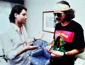O tão esperado encontro de Sergio Vid e Carlos Santana. Aqui, Vid exibe toda a discografia em vinil do guitarrista, de sua coleção. Santana fica impressionado com tamanha dedicação do fã e cantor, e autografa o LP Caravanserai, dizendo que era o seu preferido, com influências de John Coltrane. Encontro no hotel, na véspera da apresentação de ambos no Rock in Rio 2, em 19 de janeiro de 1991. – Texto: Elias Nogueira